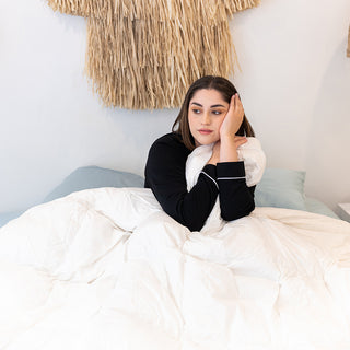 A woman enjoying a comfortable sleep on a bed with her down feather duck doona
