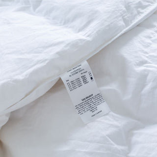 Product Tag Ultra-Warm Hungarian Goose Down Quilt in white; Cozy winter quilt on a bed.